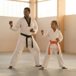 Instructor and child mirroring a taekwondo stance